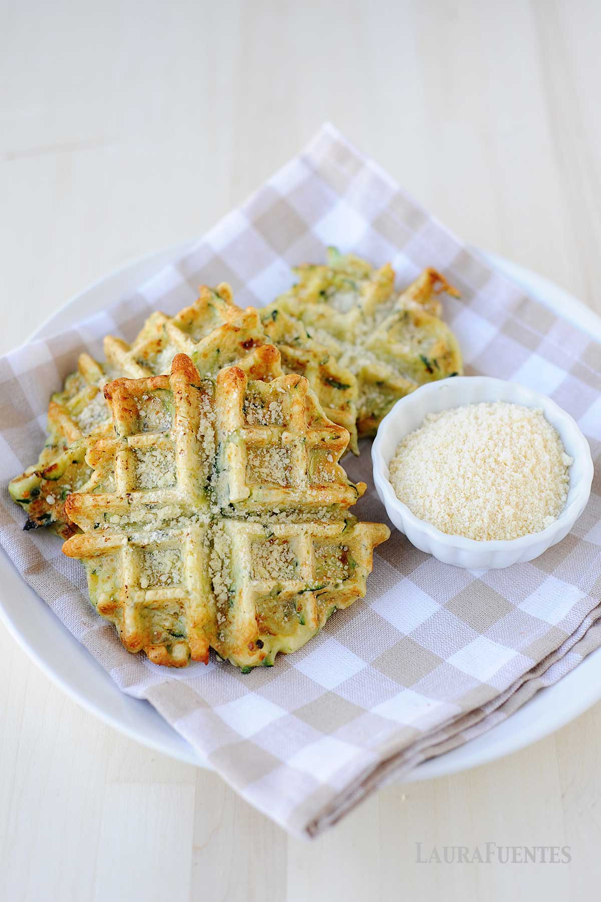 un plato con waffles de verdura y queso rallado