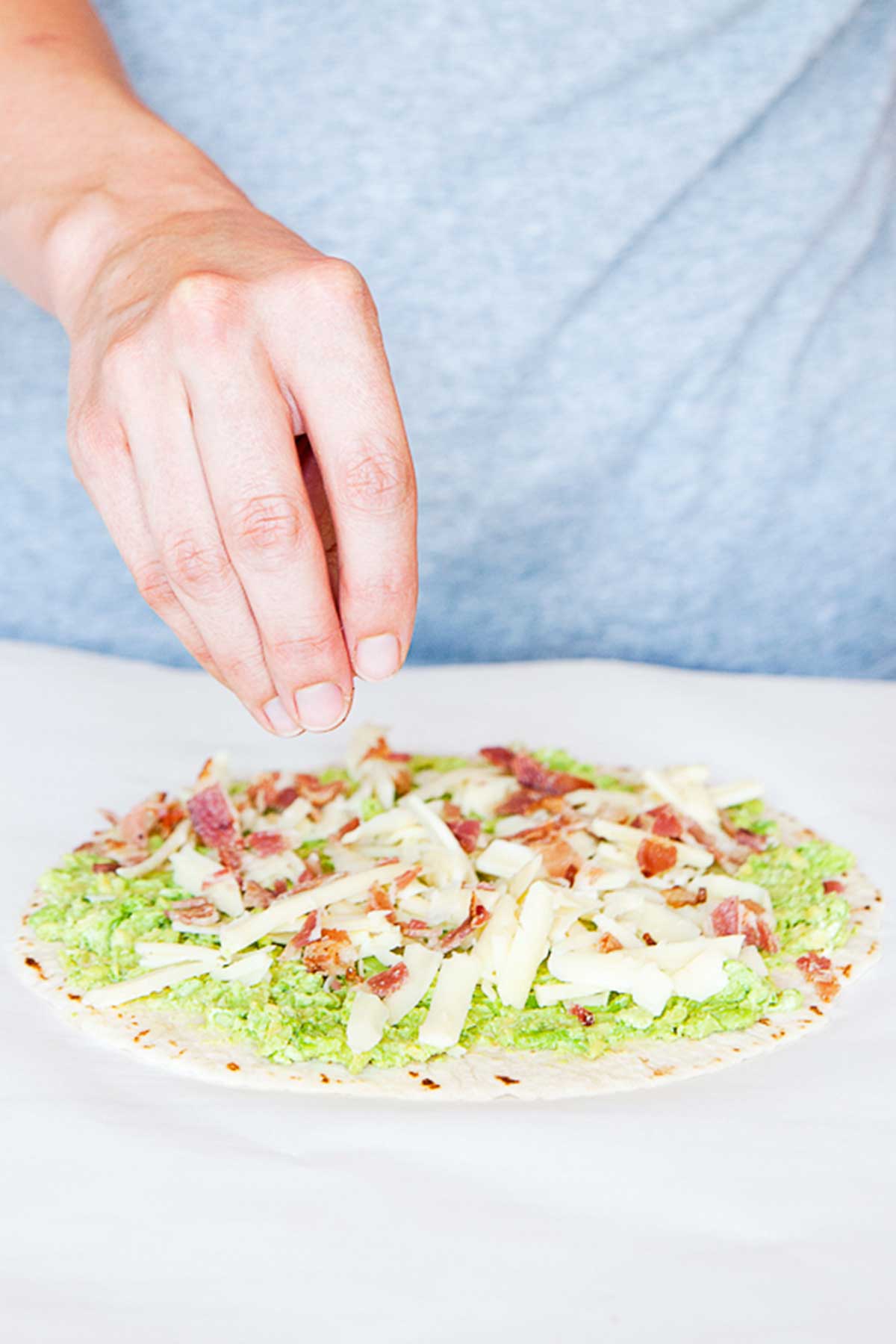 un wrap con aguacate, queso rallado, y bacon