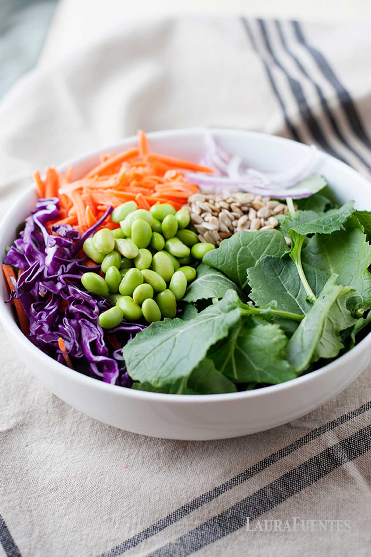 un bol de ensalada de kale con col, edamame y zanahoria