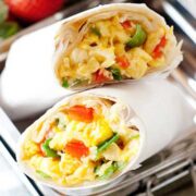 burrito de huevo cortado a la mitad en una lonchera con frutas
