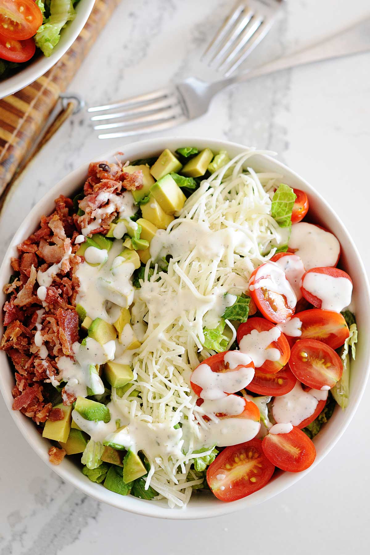 un bol de ensalada de lechuga, tomate y aguacate