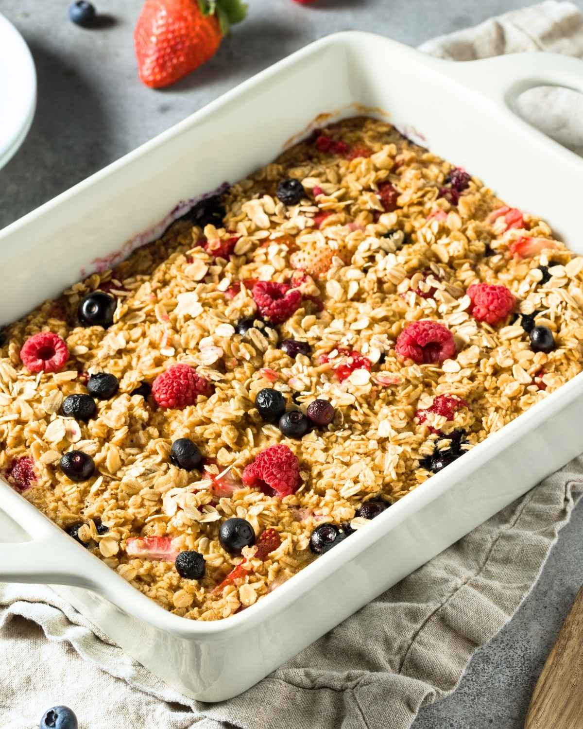 una fuente blanca con avena horneada con frutos rojos