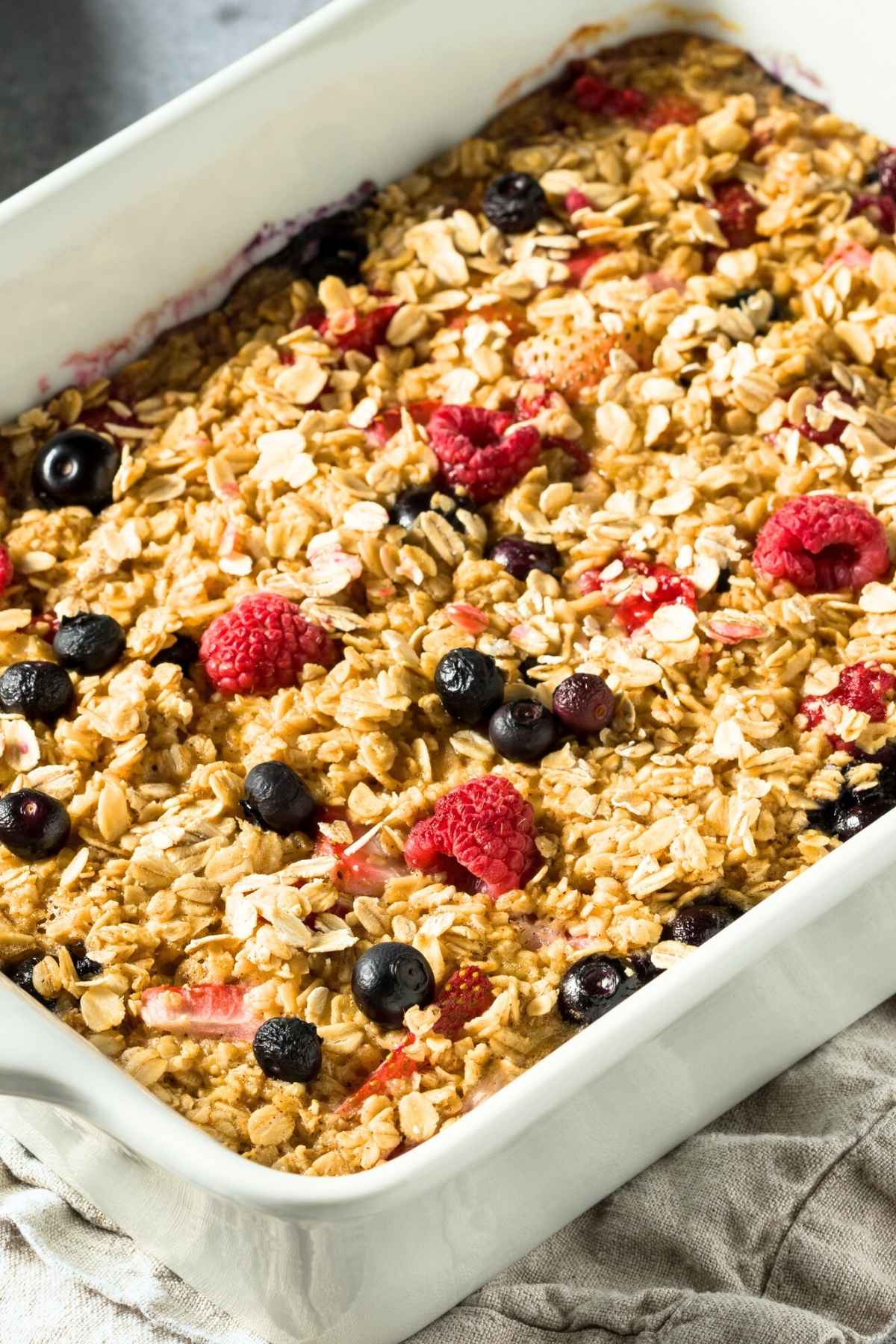 una fuente blanca con avena horneada con frutos rojos