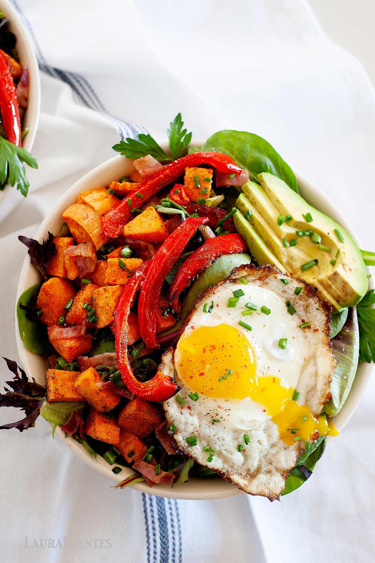 Ensalada para cenar saludable con huevo frito, aguacate, pimientos y batata. 