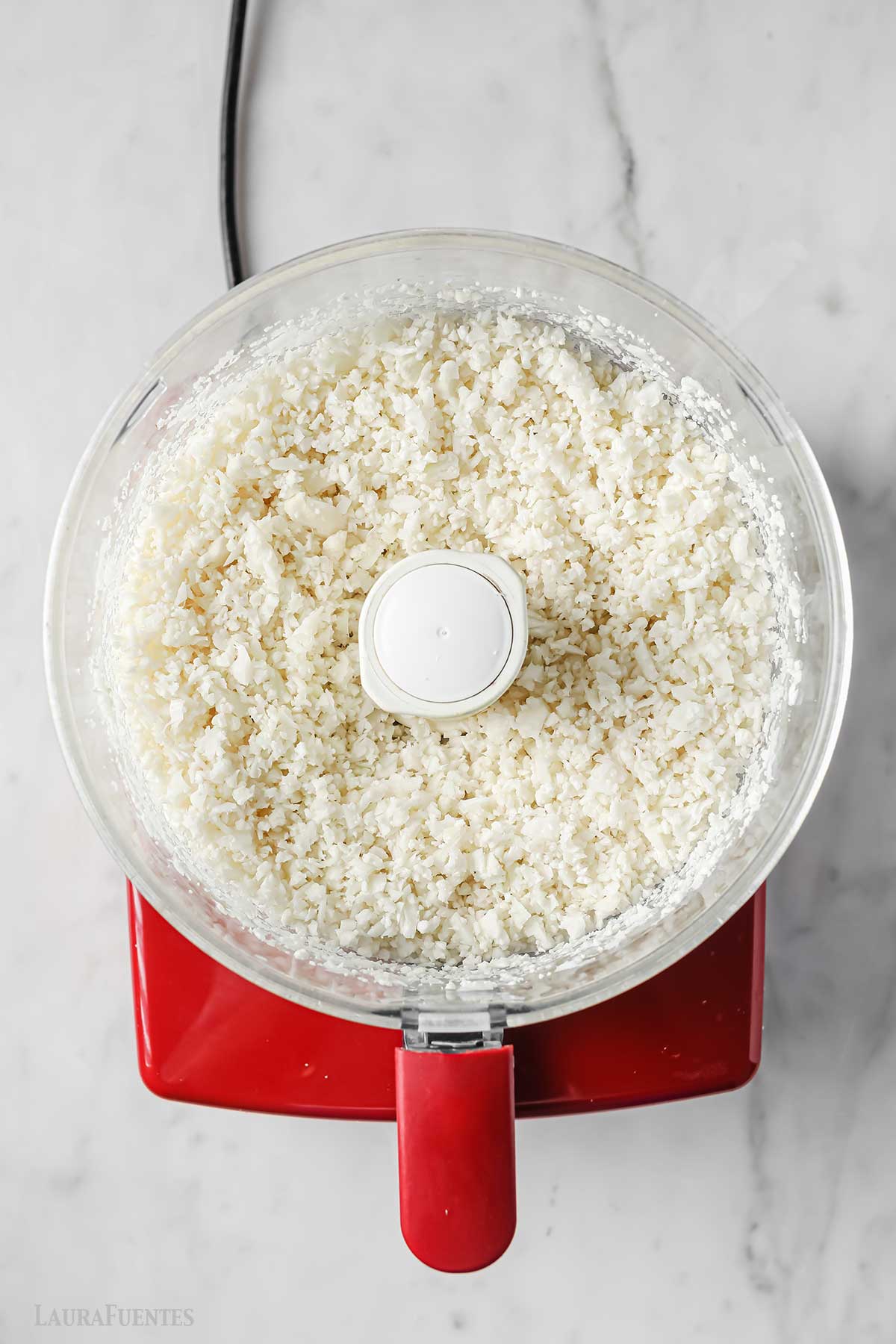 arroz de coliflor dentro de un procesador de alimentos