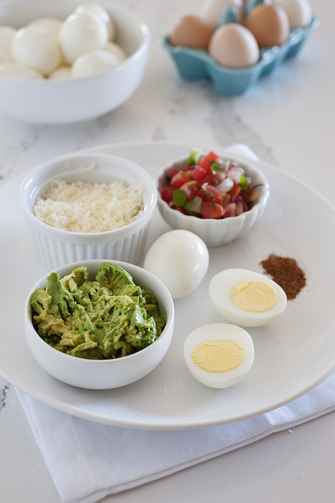 huevos hervidos en un plato guacamole en un bol