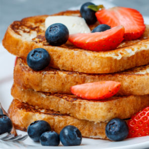 una pila de torrijas con fretos rojos