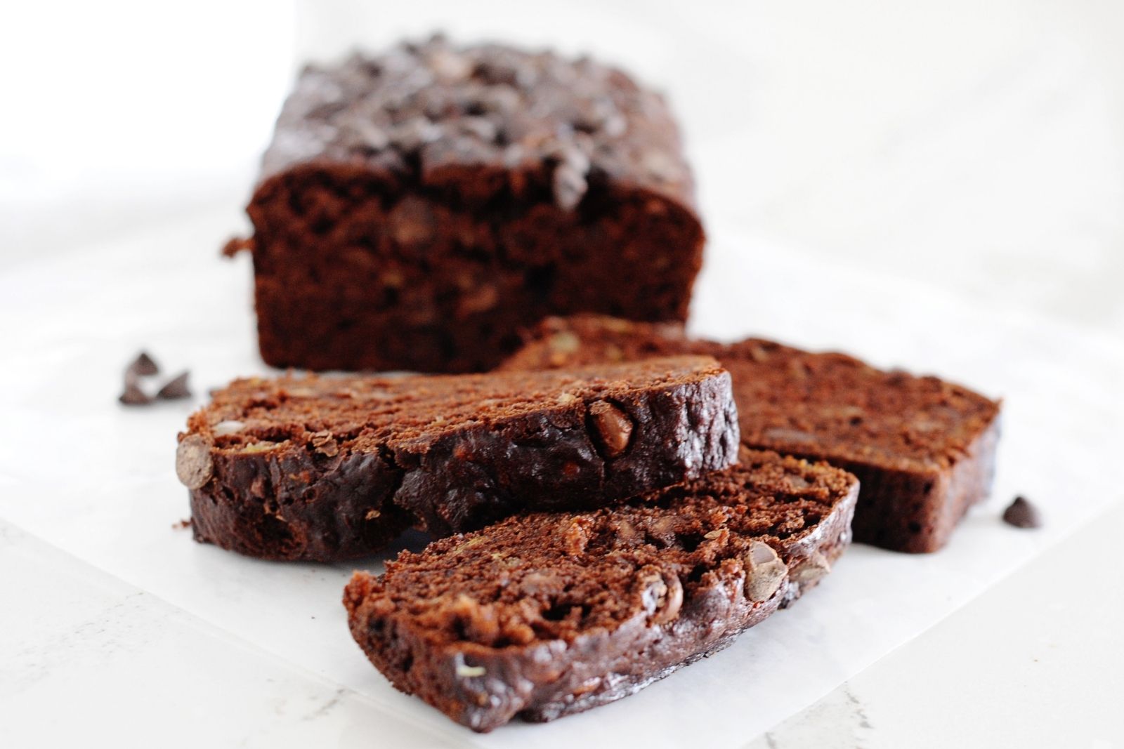 tres rodajas de bizcocho de chocolate y el resto del bizcocho detrás 