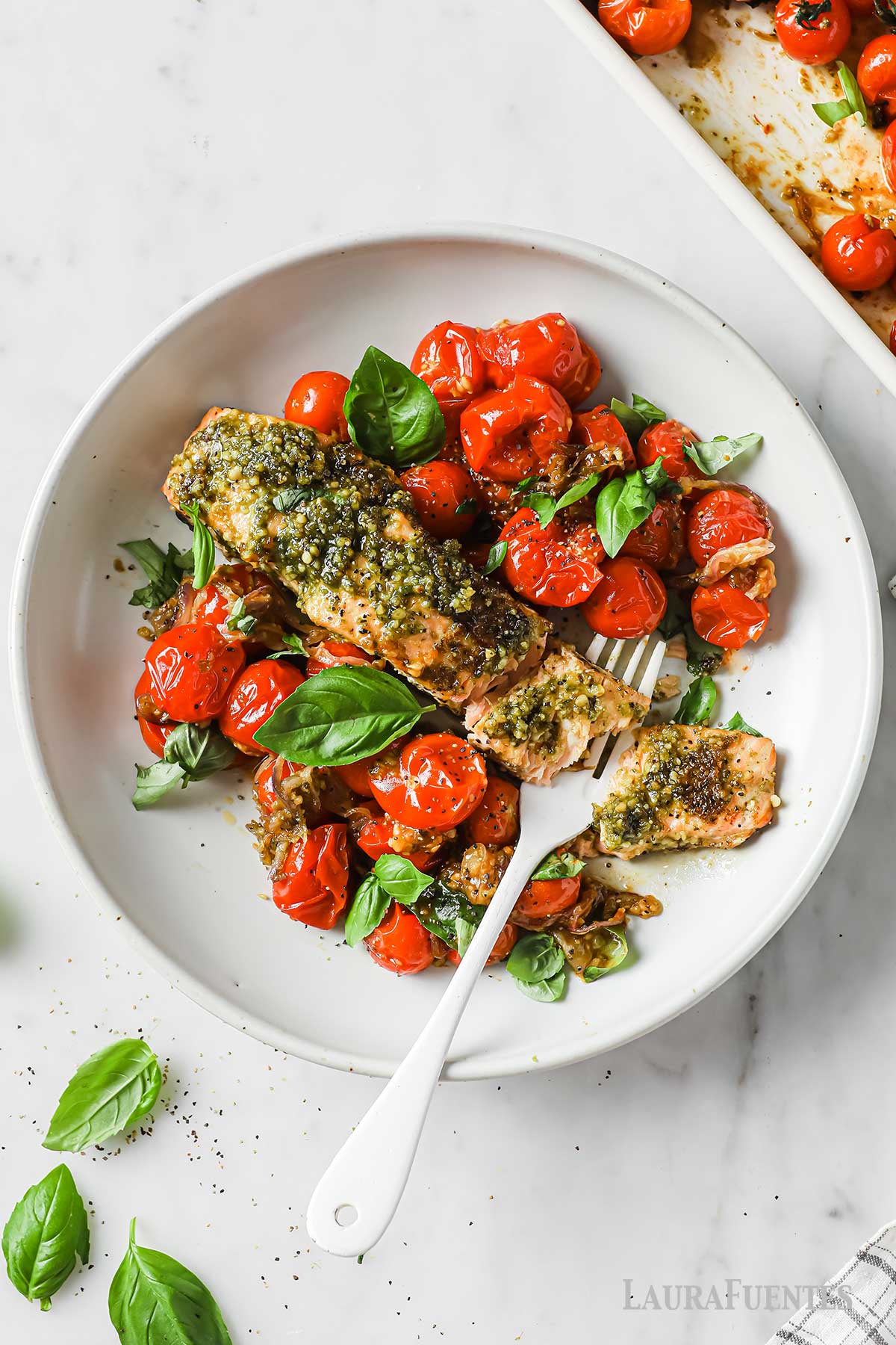 Salmón al Pesto al Horno con tomates y albahca en un plato