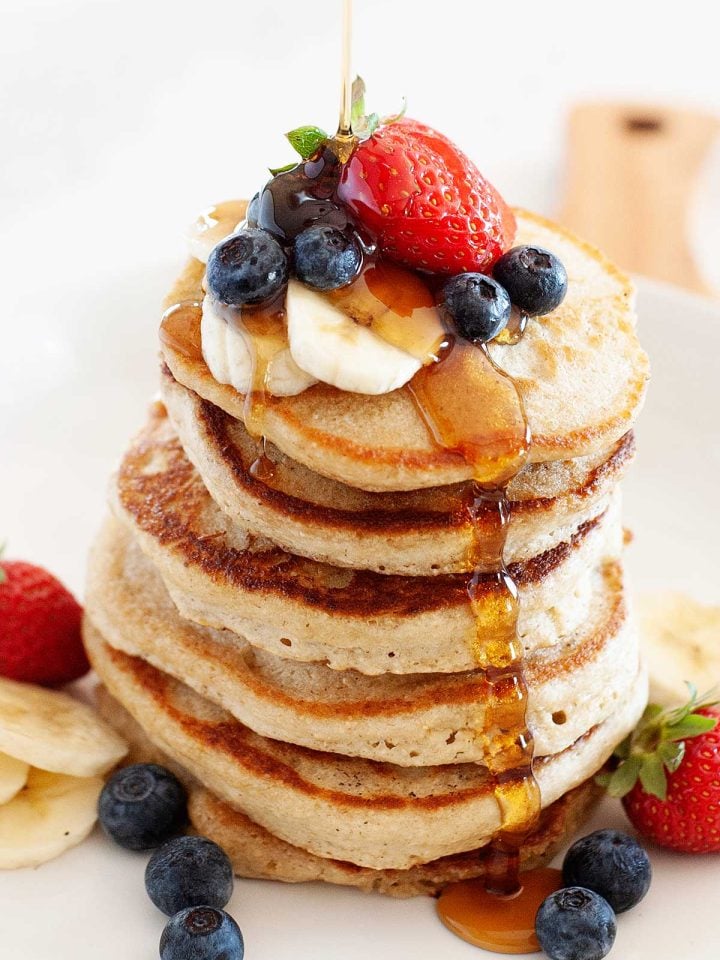Tortitas de avena esponjosos con arándanos, fresas, y sirope de arce.
