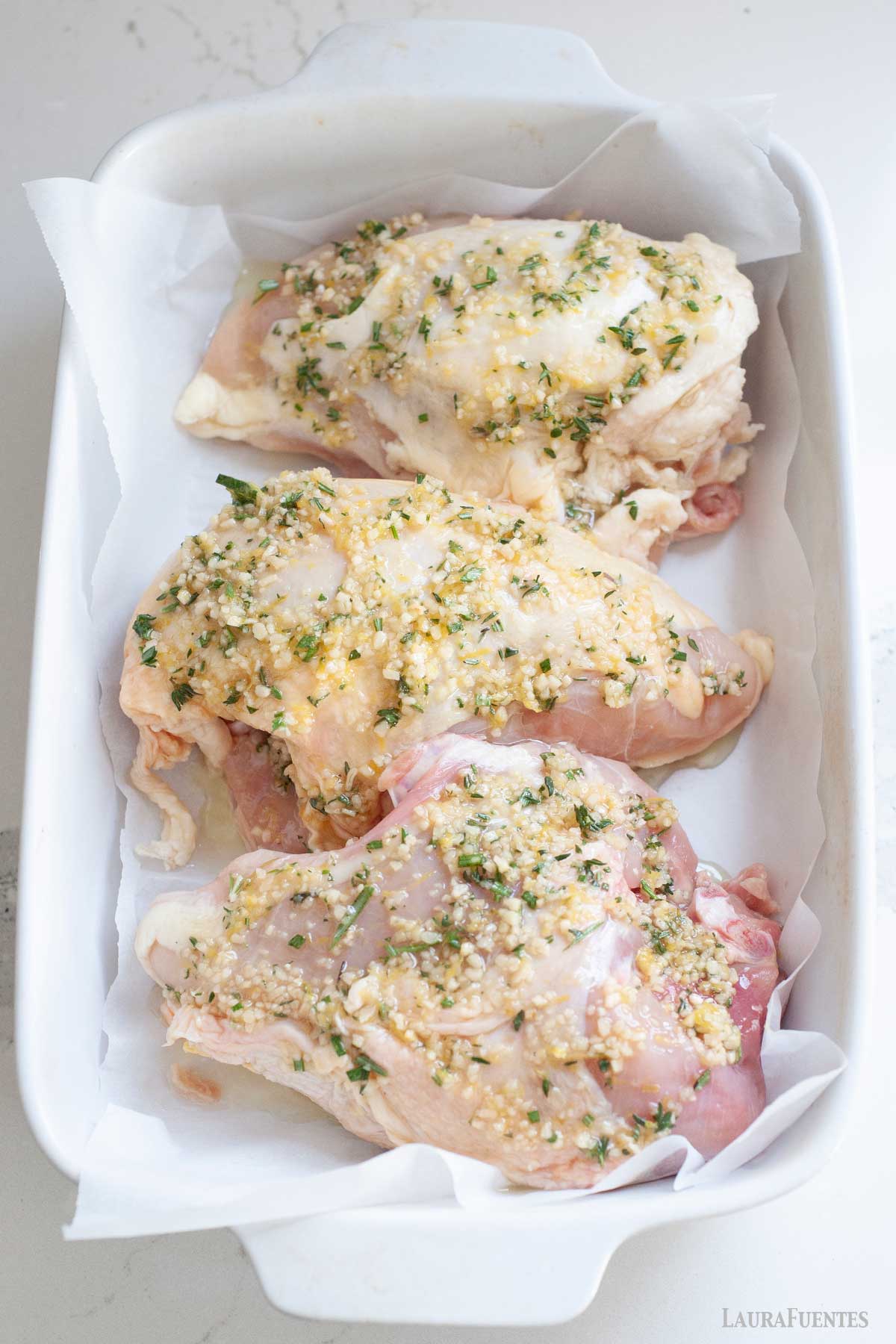 Tres pechugas de Pollo con Hueso crudas en una fuente.
