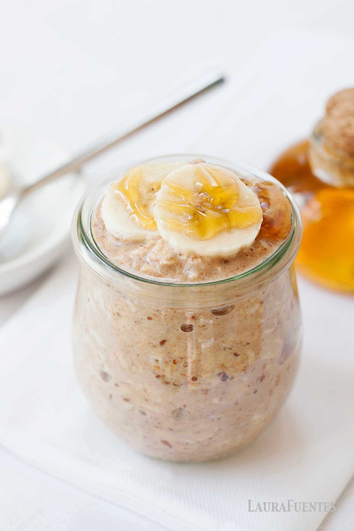 un frasco de avena nocturna con miel y plátano