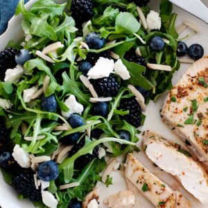 pollo con ensalada de rúcula, arándanos y queso