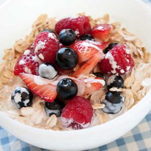 avena fría con leche y frutos rojos en un bol