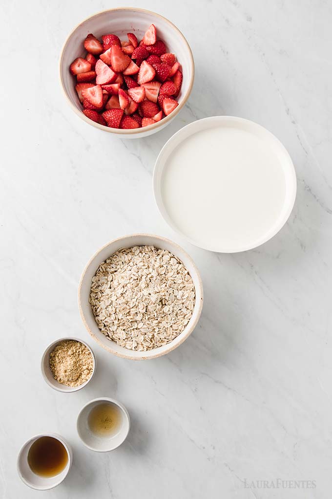 recipientes con fresas, leche, avena cruda, linaza, extracto de vainilla
