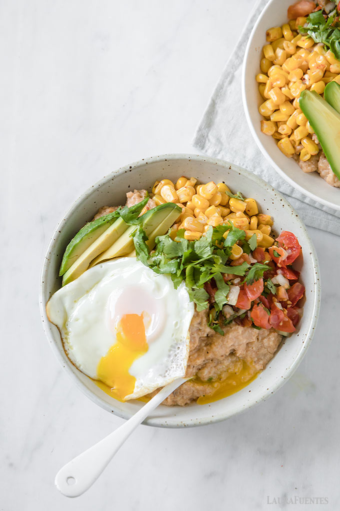 un bowl con avena cocida, huevo frito, aguacate, pico de gallo y cilantro