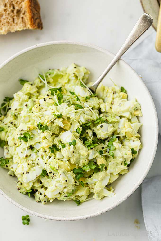 un recipiente con ensalada de aguacate y huevo