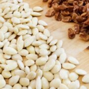 a la izquierda, almendras peladas, a la derecha, la piel de las almendras.