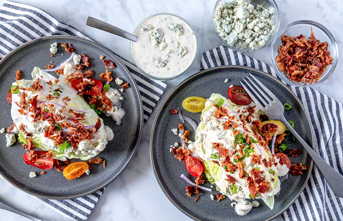 dos platos con ensalada sazonadas con aderezo roquefort