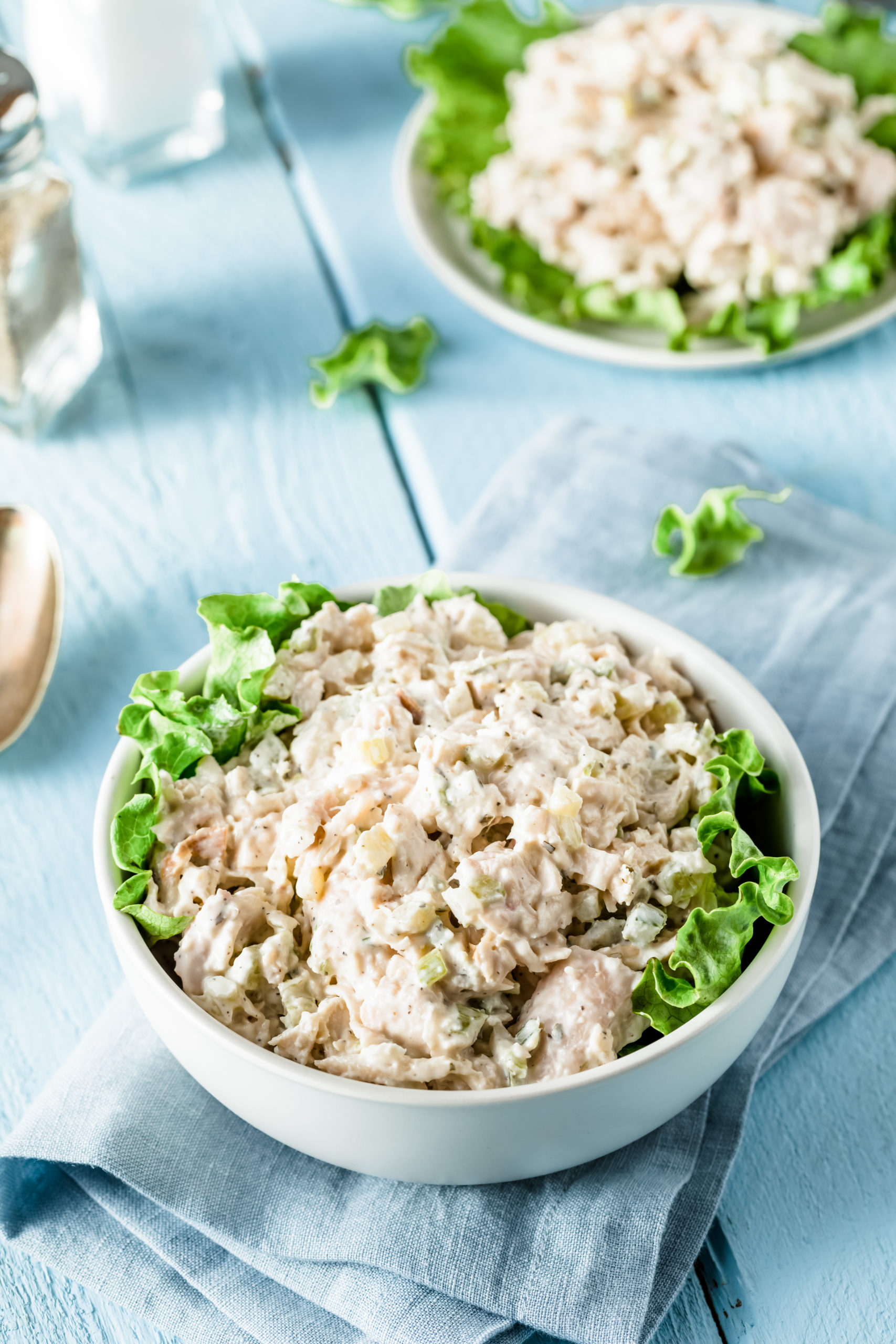 un recipiente con ensalada de pavo y hojas de lechuga