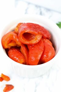 un recipiente con pimientos rojos asados al horno