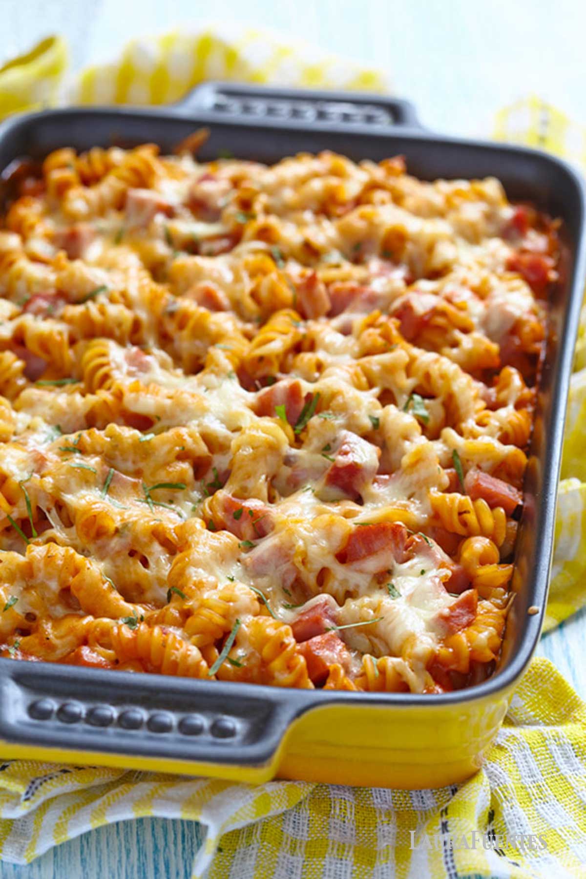 una fuente de pasta al horno gratinada con albahaca, jamón y queso