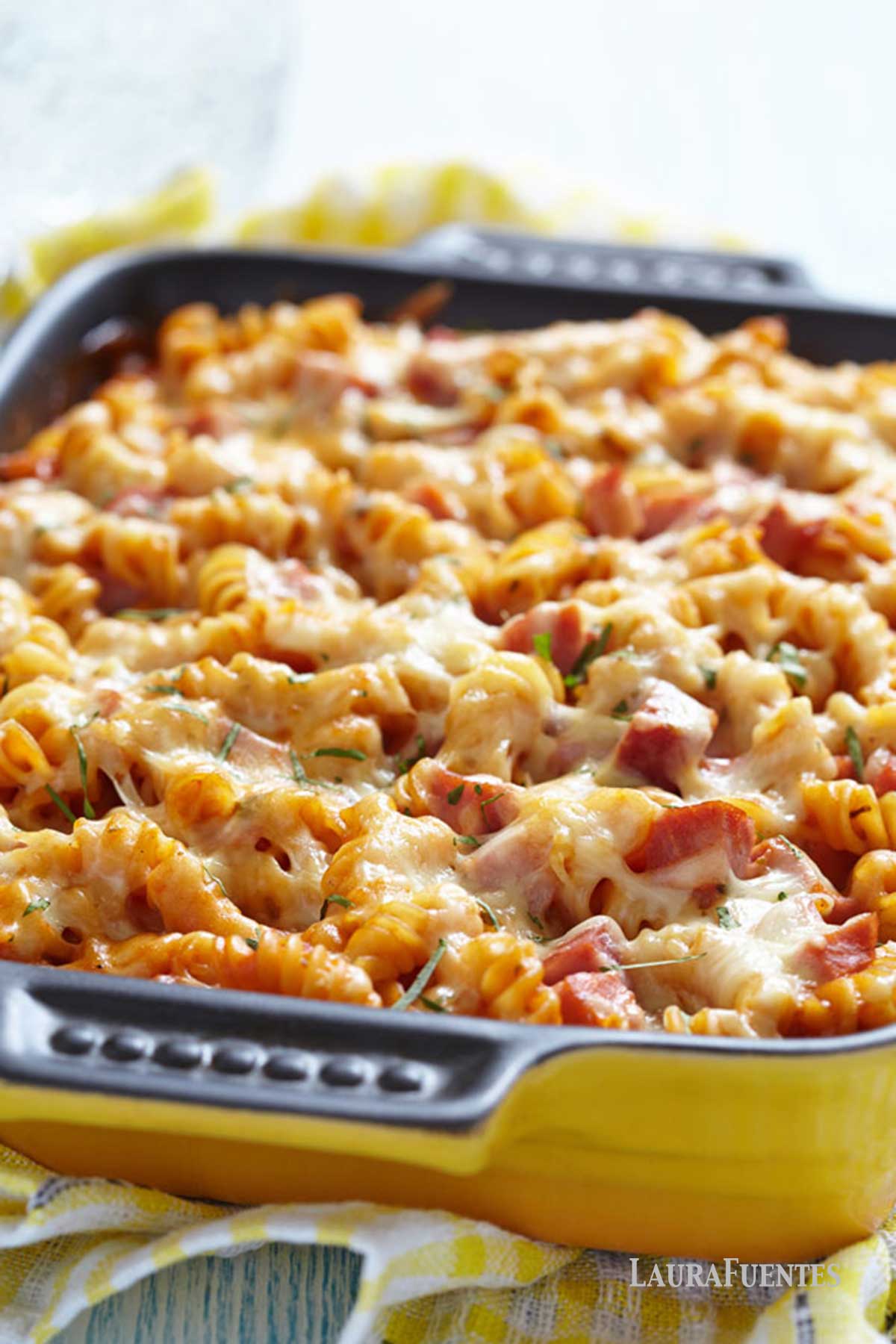 una fuente de pasta gratinada con albahaca, queso y tomate