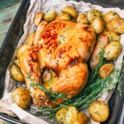 pollo asado al horno condimentado en una badeja con patatas