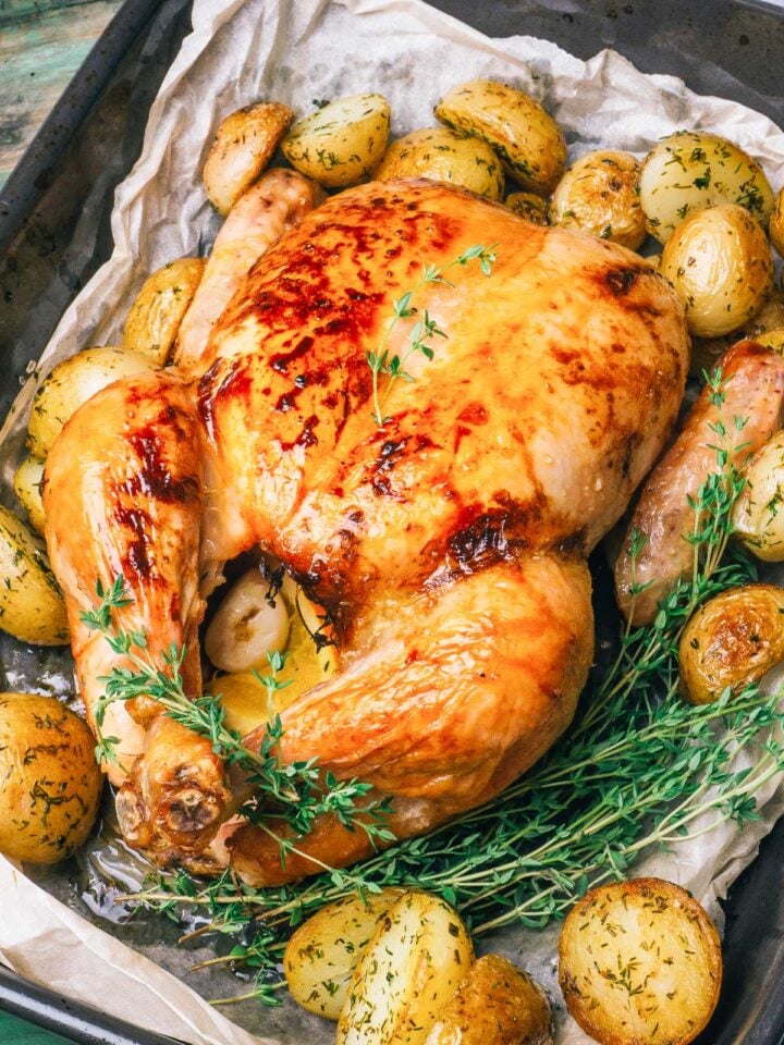 pollo asado al horno condimentado en una badeja con patatas