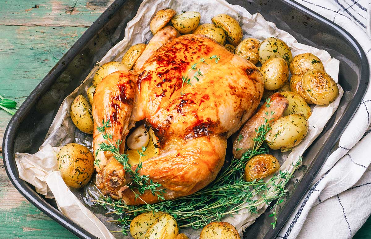 pollo asado al horno condimentado en una badeja con patatas