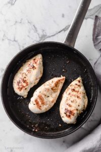 tres pechugas de pollo en una plancha