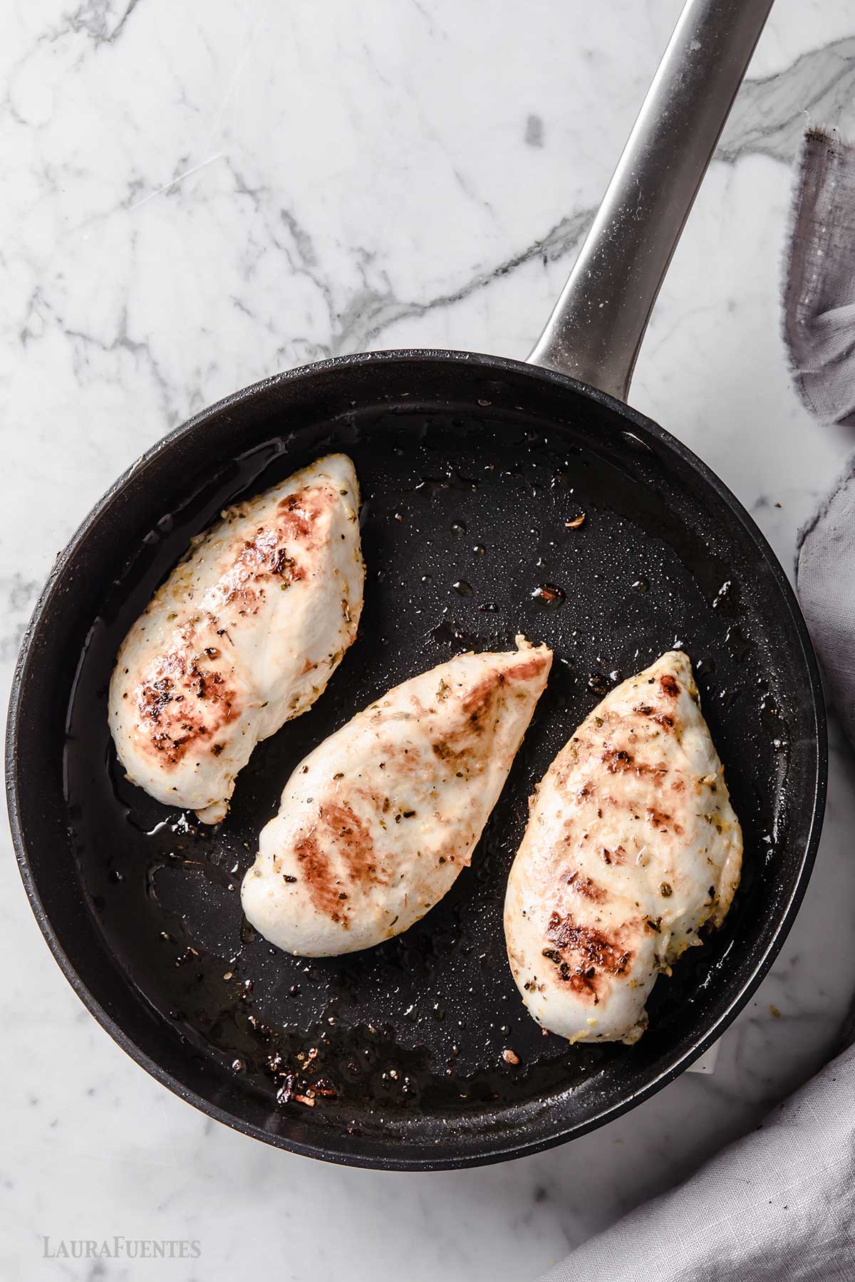tres pechugas de pollo en una plancha