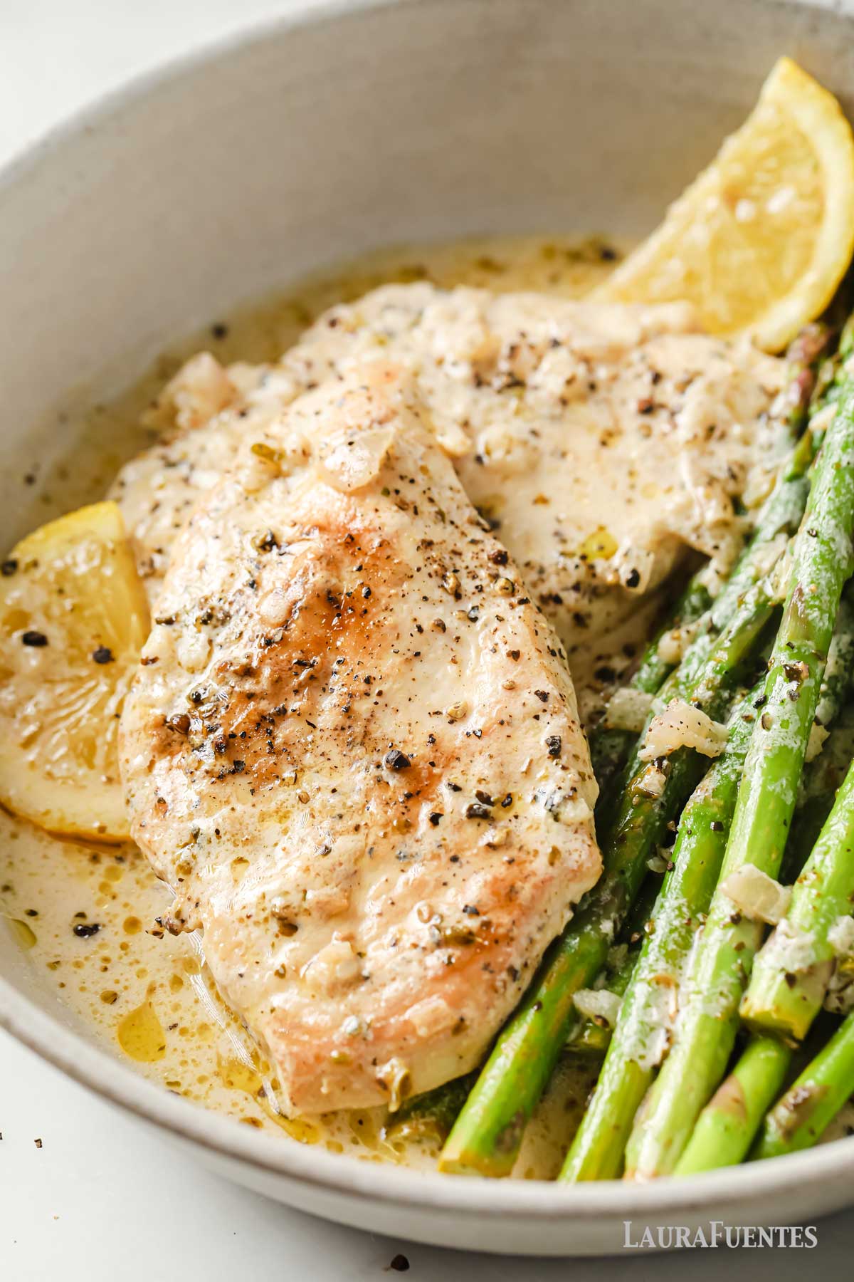 un plato de pollo con espárragos y limón