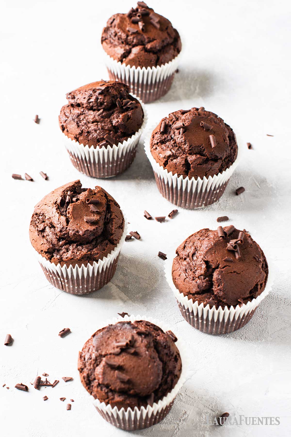 seis magdalenas de chocolate sobra una superficie blanca