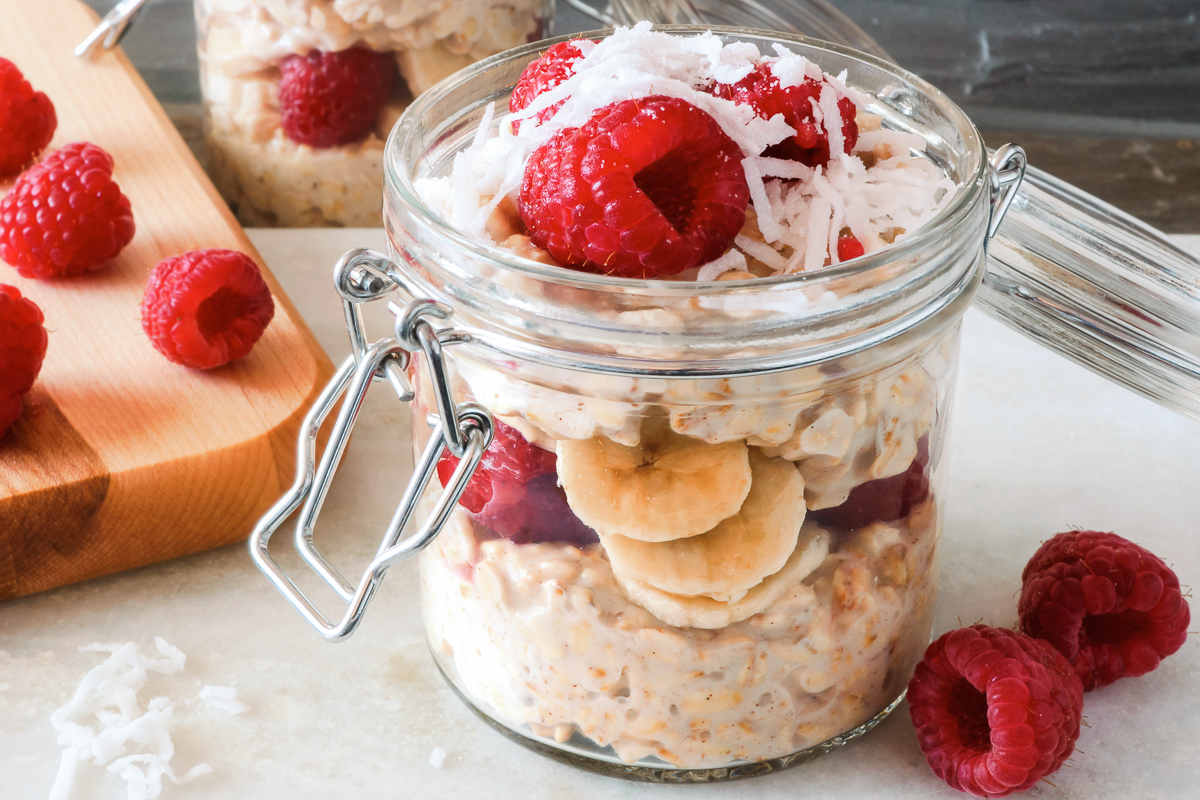 un frasco de avena remojada con plátano y moras