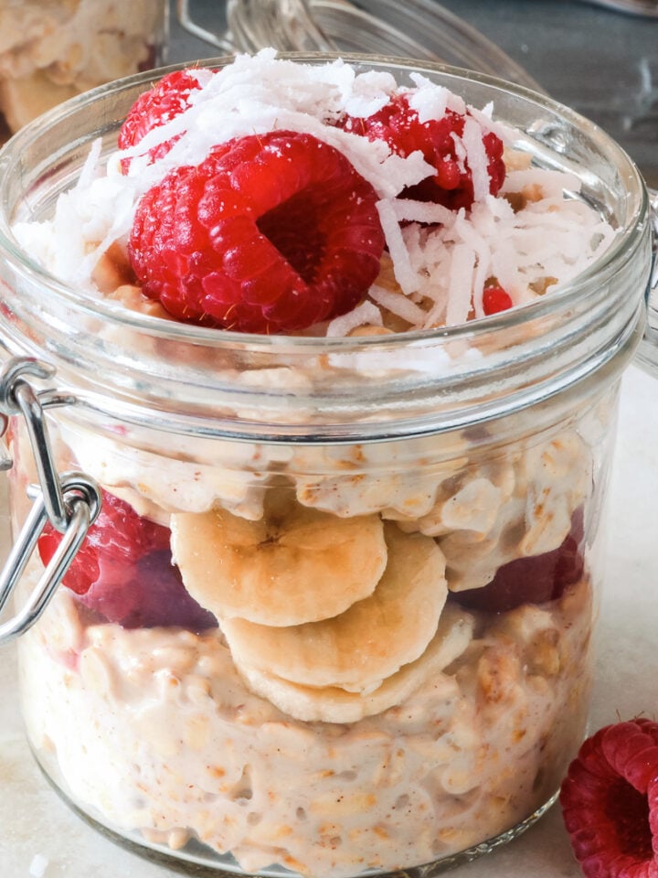 un frasco de avena remojada con plátano y moras