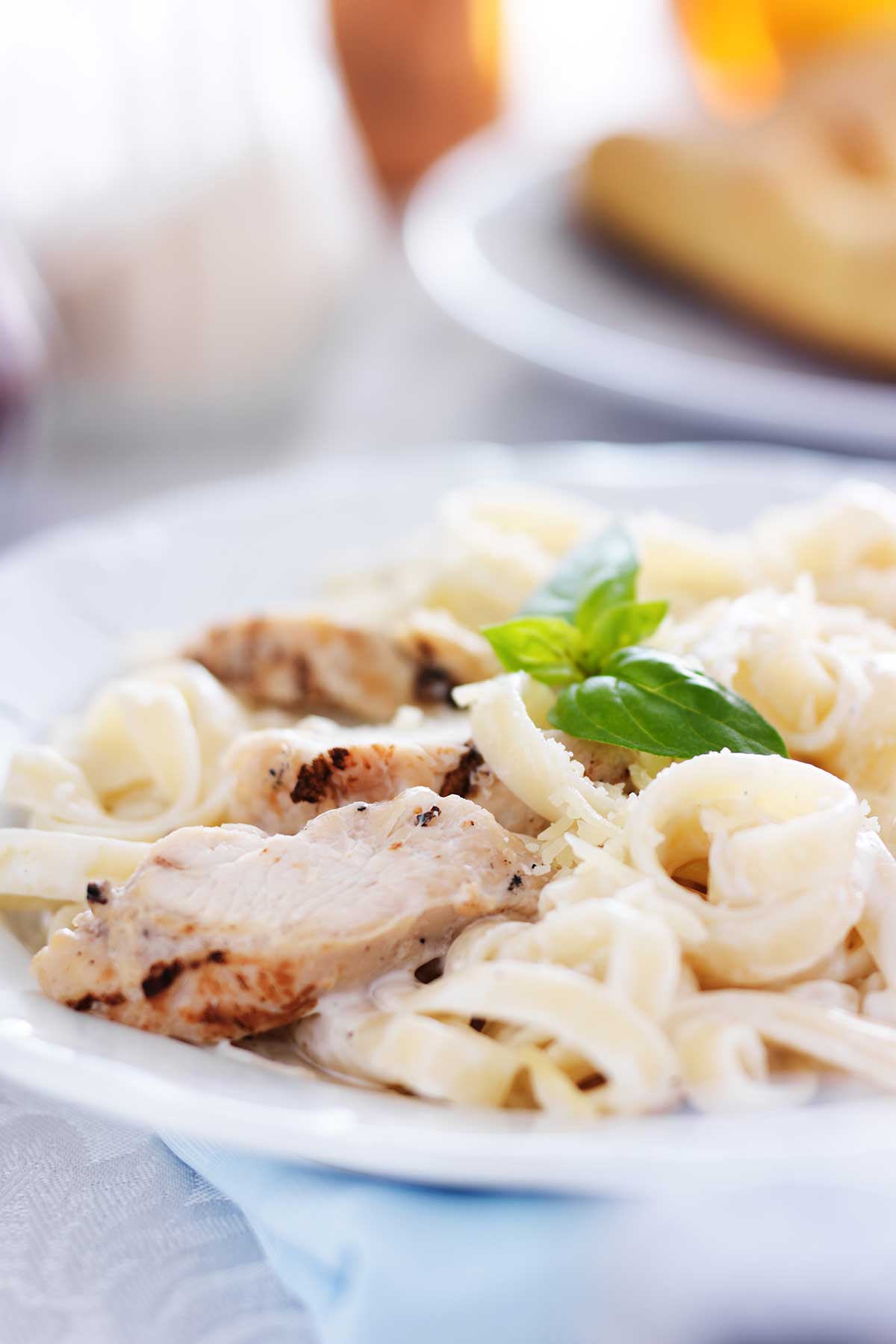 un plato de pasta con salsa alfredo y pollo