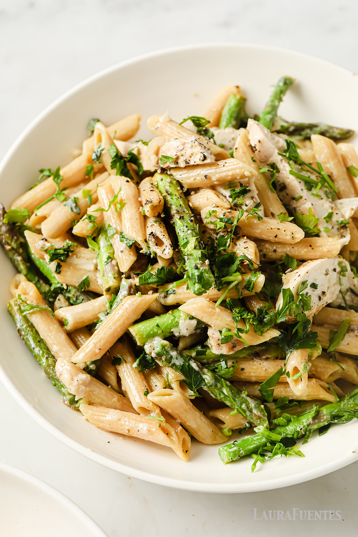 un plato de pasta con espárragos y pollo