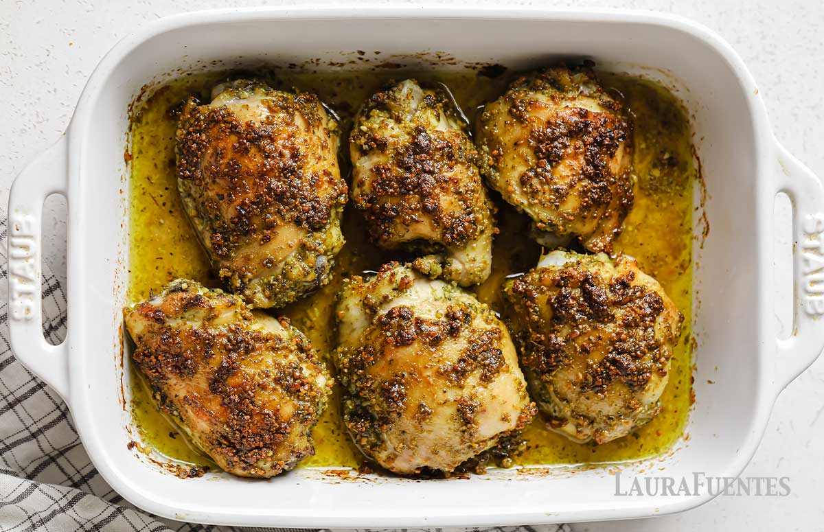 seis muslos de pollo al pesto en una fuente, vistos desde arriba