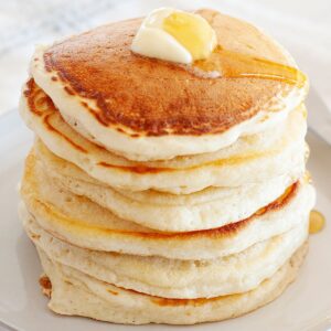 una pila de tortitas sin huevo con mantequilla y sirope por encima