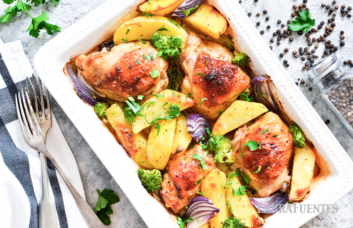 una bandeja de horno con piezas de pollo, patatas y cebolla