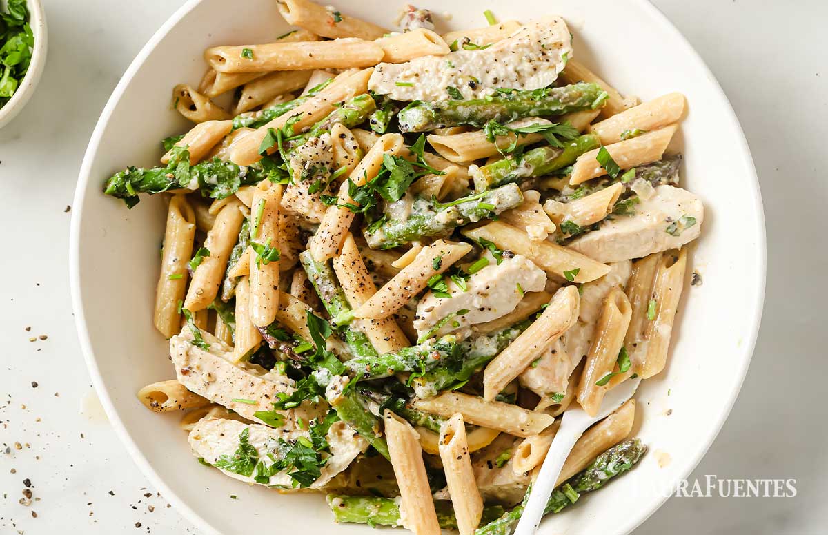 vista cenital de un plato de pasta con pechuga de pollo y espárragos