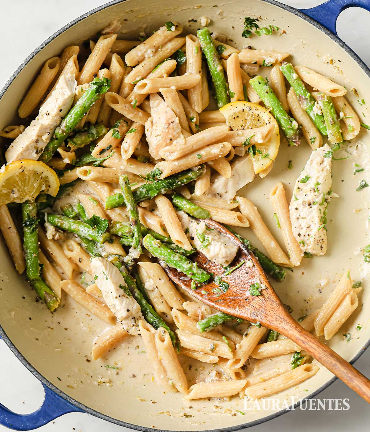 una sartén con pasta con pechuga de pollo y espárragos