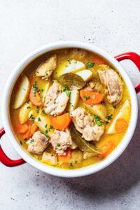 una olla con guiso de pollo y patatas, vista desde arriba