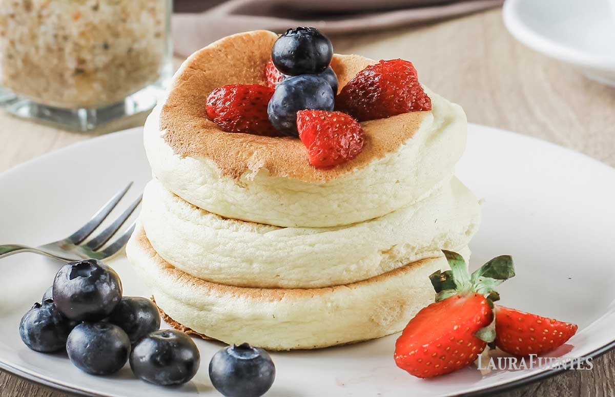 tres tortitas japonesas con frutos rojos alrededor y por encima