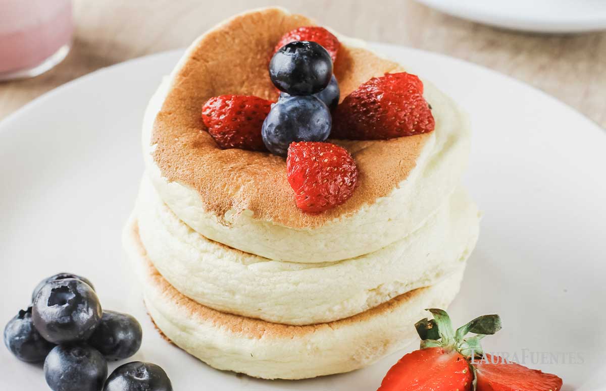 tres tortitas japonesas con frutos rojos alrededor y por encima