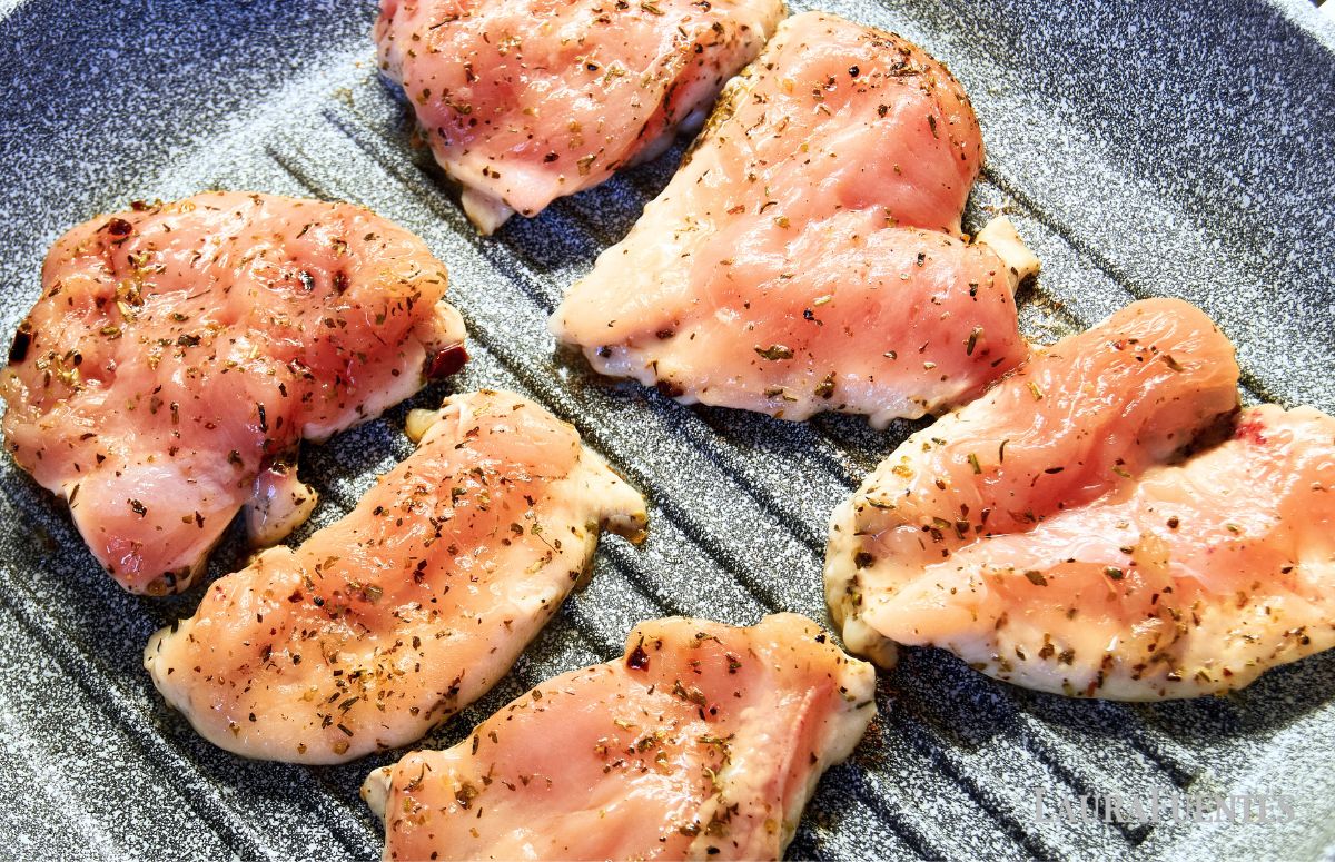 seis contramuslos de pollo cocinándose en una sartén