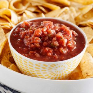 un recipiente con salsa taquera rodeado de nachos