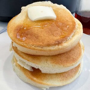 una pila de tortitas con mantequilla por encima
