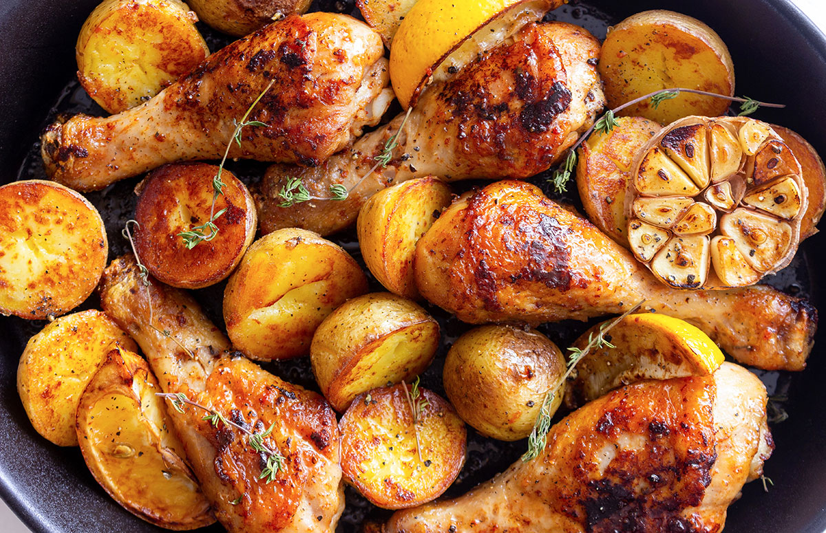 vista cenital de muslos de pollo con patatas al horno